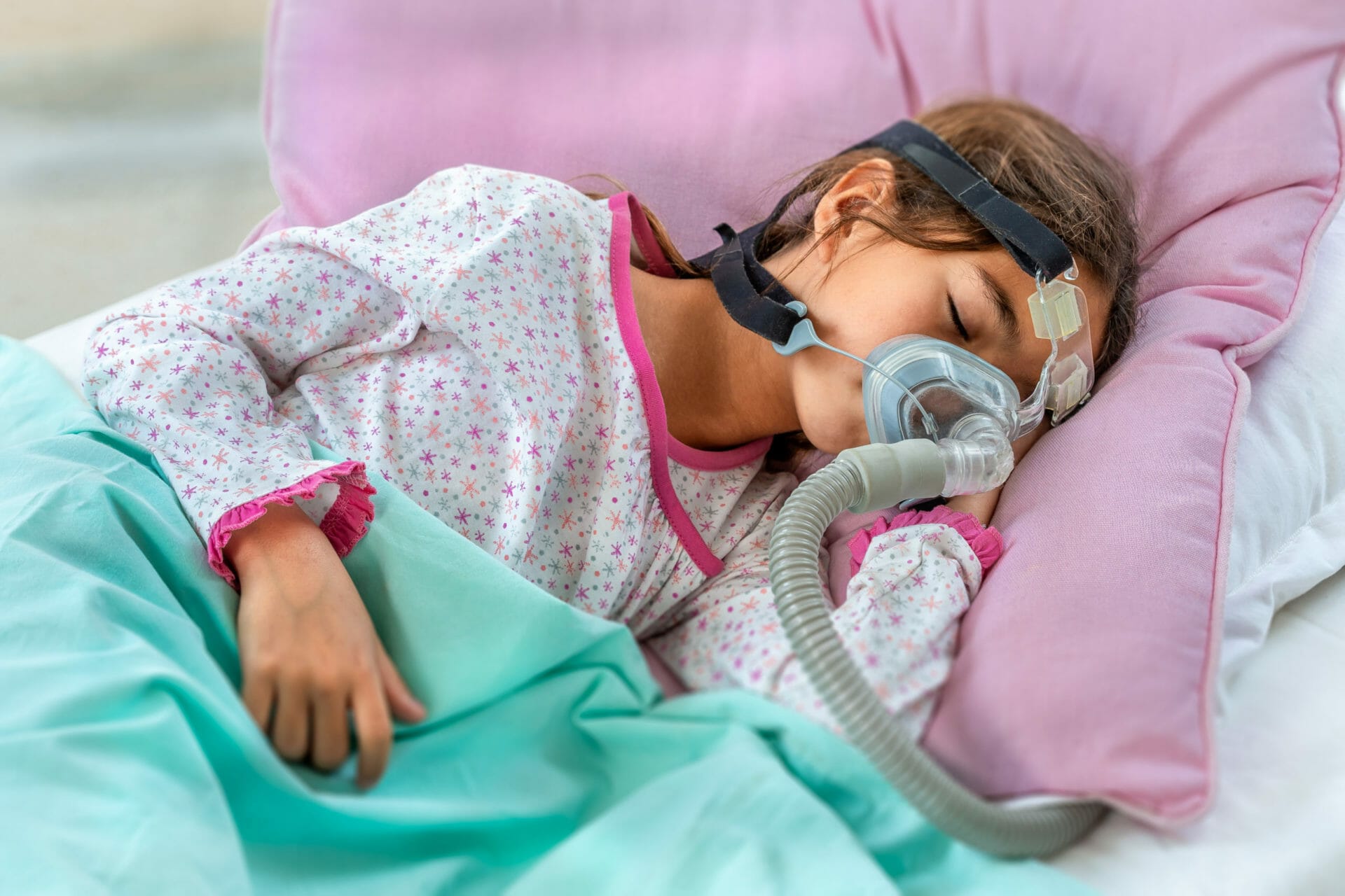 Child suffering from sleep apnoea using a machine to assist with breathing